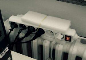 Elektrická prodlužka upevněná na radiátoru
